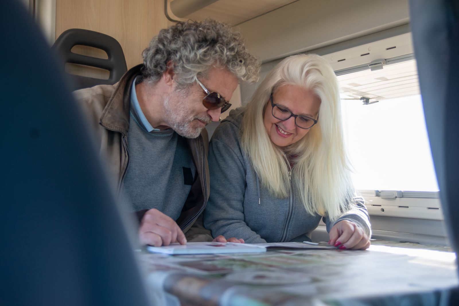 An older couple reviewing travel plans together at a table, judging which of the best cruise advisors to trust